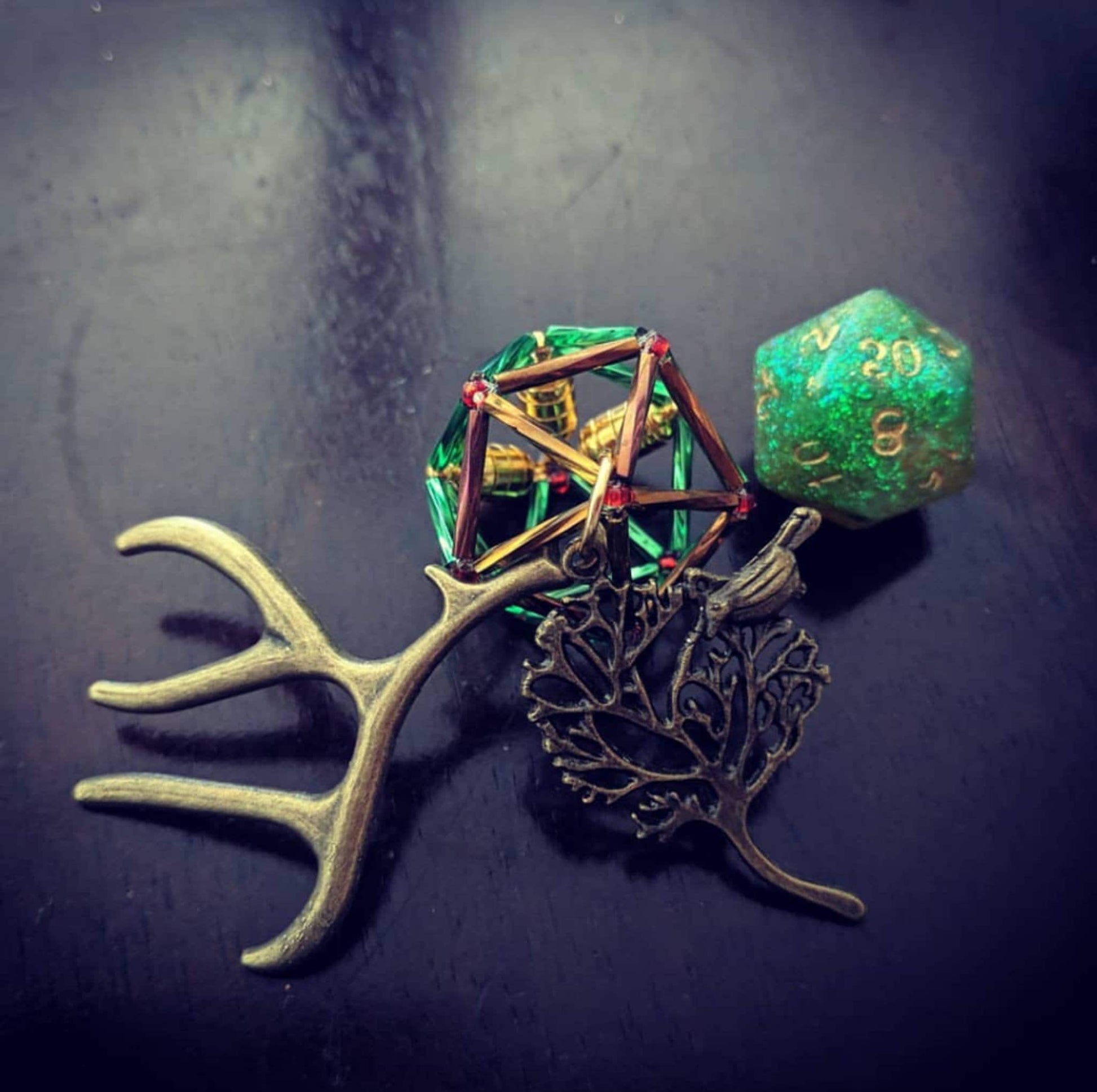 Keyleth necklace: green and reddish brown cage with two charms. Bronze antler and tree with birds charm.